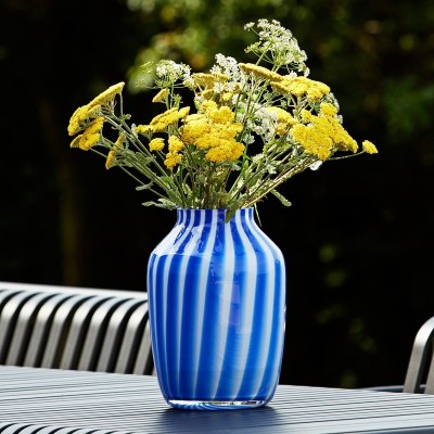 Imagen ambientada Juice Vases tall blue con flores amarillas de HAY Imagen ambientada Juice Vases tall blue con flores amarillas de HAY