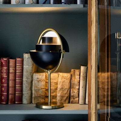 Imagen ambientada en estantería Multi Lite portable lamp latón con pantalla negra mate de Gubi Imagen ambientada en estantería Multi Lite portable lamp latón con pantalla negra mate de Gubi